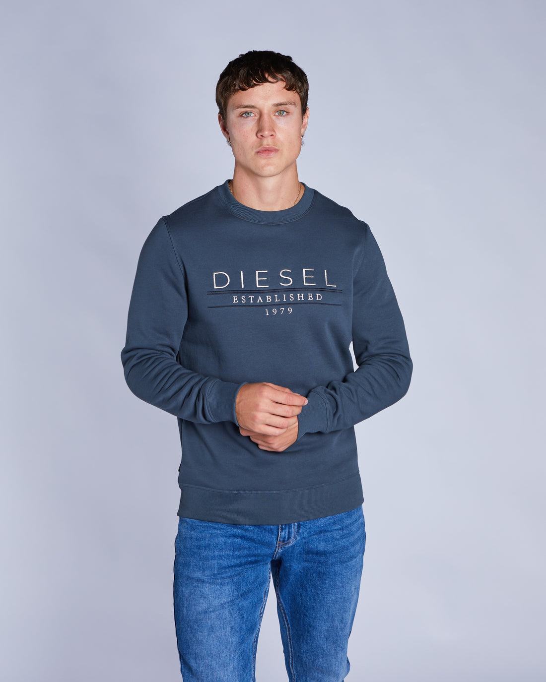 Man wearing a blue crew neck sweatshirt