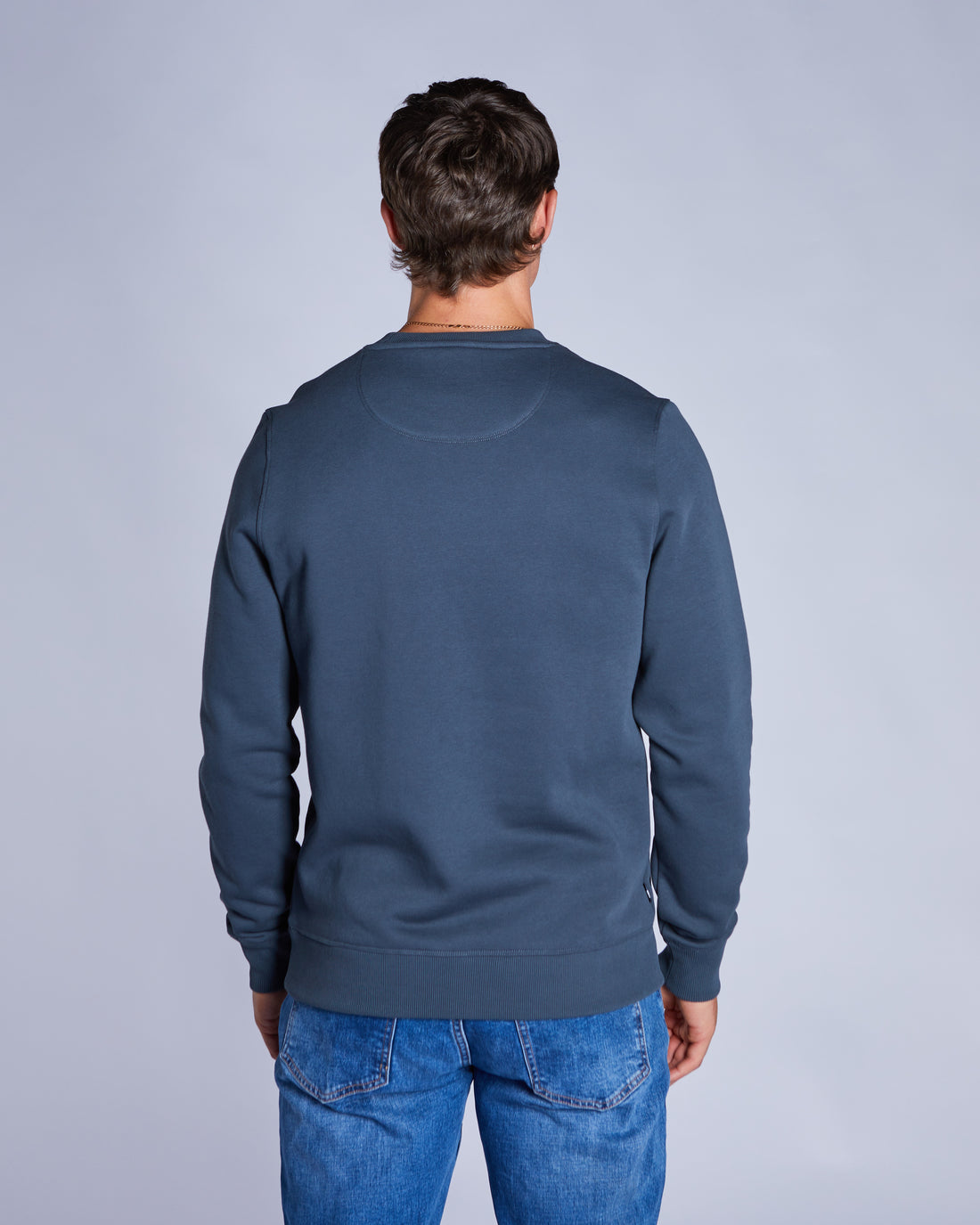 Man wearing a blue crew neck sweatshirt back view