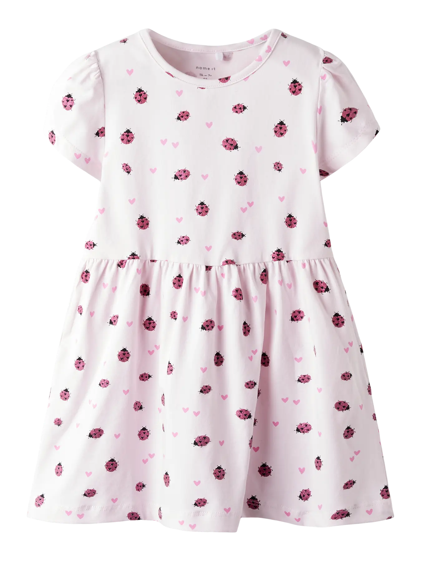 White dress with pink ladybug pattern on a white background
