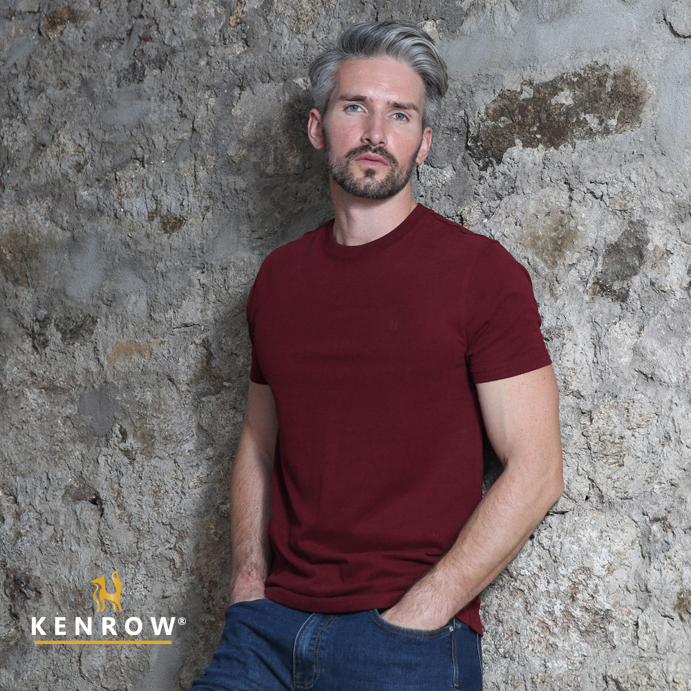 Man wearing a maroon t-shirt against a textured stone wall with 'Kenrow' branding.
