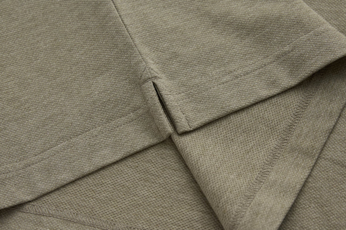 Detailed view of the brindle 6th Sense Evoke Polo side seam and hem stitching.