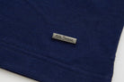 6th Sense metal logo badge on the lower hem of the Evoke dress blue polo