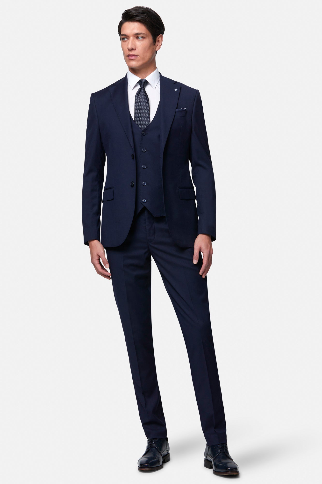 Man wearing the Benetti Edina navy blue suit with a white shirt and black shoes on a white background