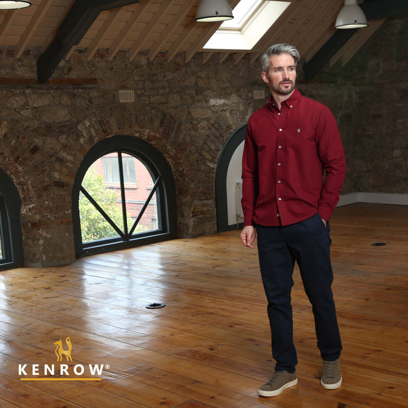 Man wearing a ruby coloured shirt looking left