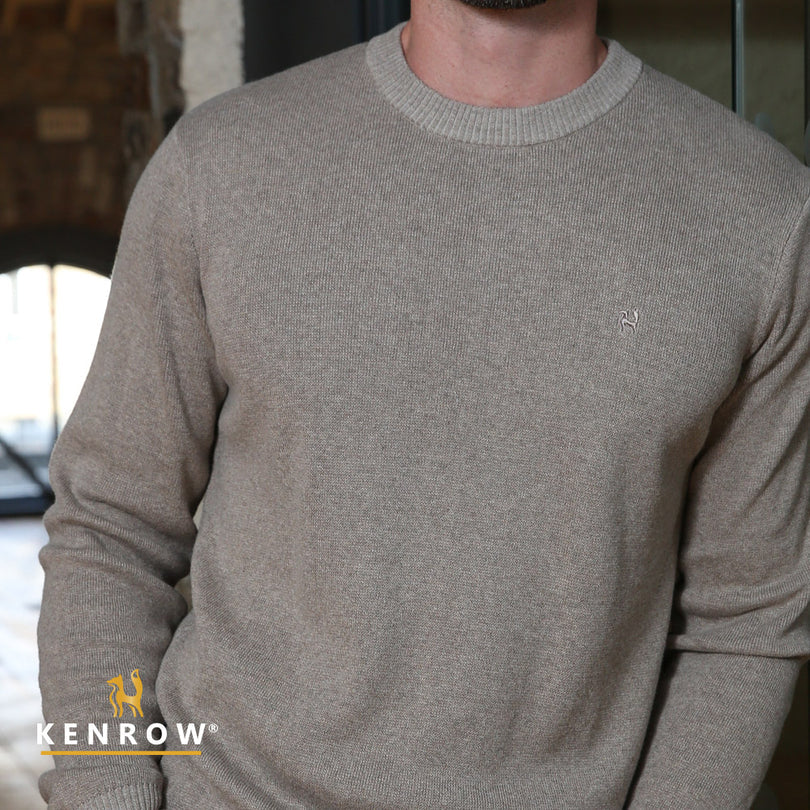 Close up of a man wearing a sand colour crew neck jumper
