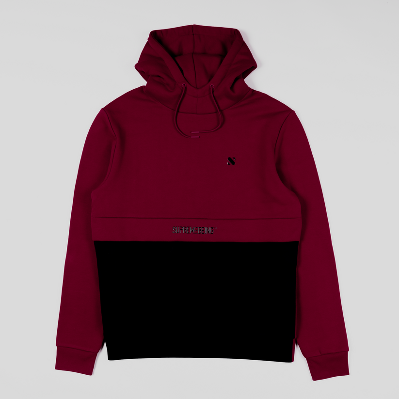 Two-tone red and black hoodie with a brand logo on a light gray background