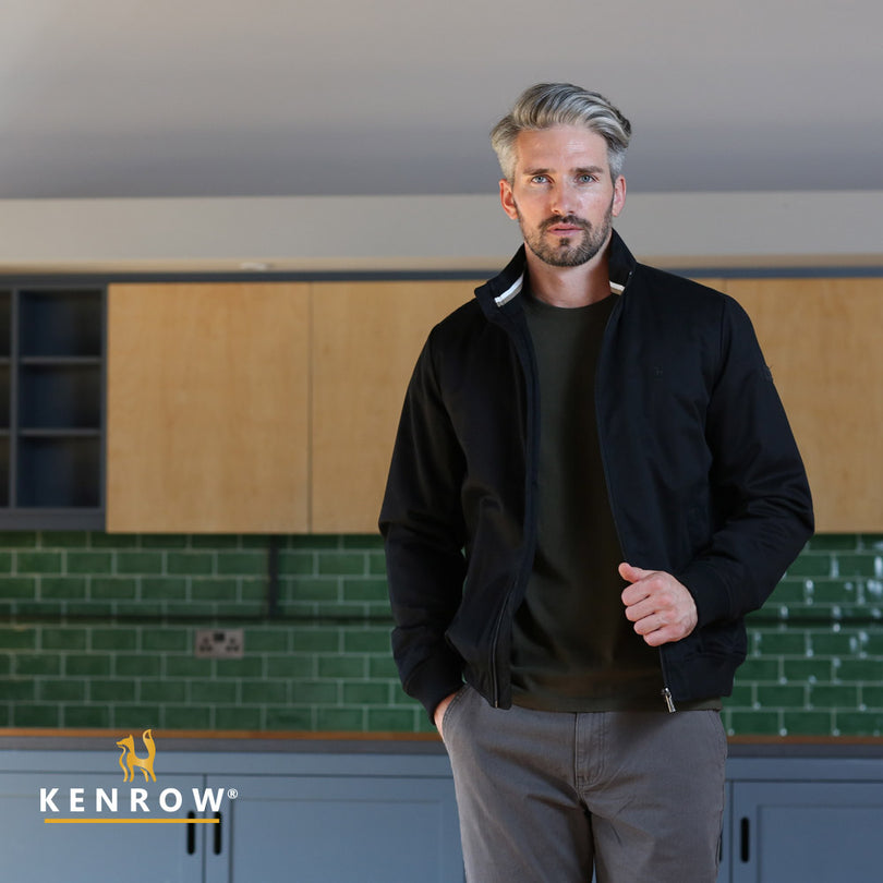 Man wearing a black harrington/bomber style jacket. close up view