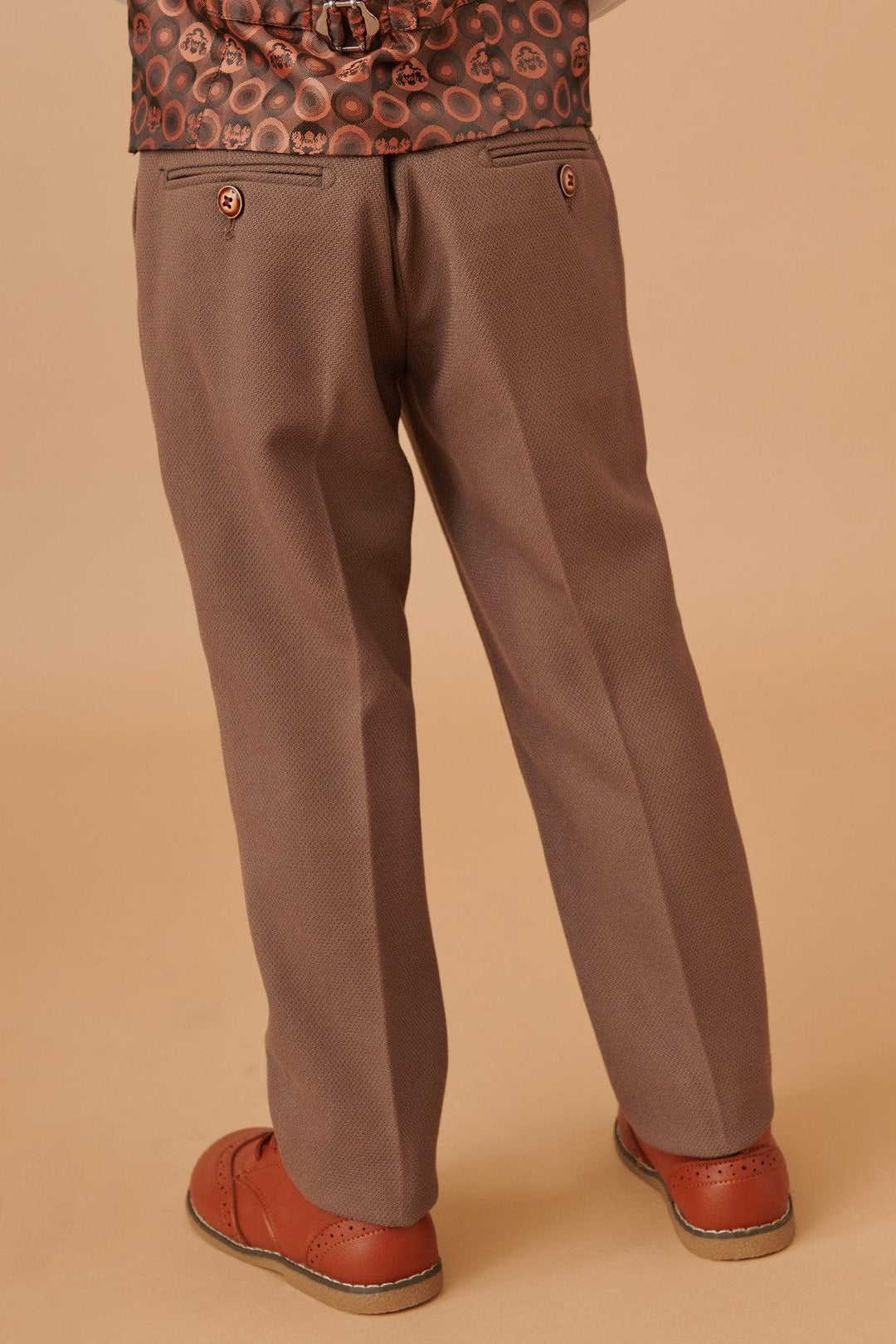 Brown pants worn by a person on a beige background