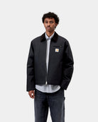 Carhartt WIP Detroit Jacket (Winter) in Dark Navy / Black, front view, worn by model with corduroy collar, chest zip pocket and zip closure visible.