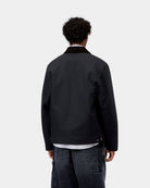 Carhartt WIP Detroit Jacket (Winter) in Dark Navy / Black, back view, showing the corduroy collar and dark jacket with a straight hem, shown on model.