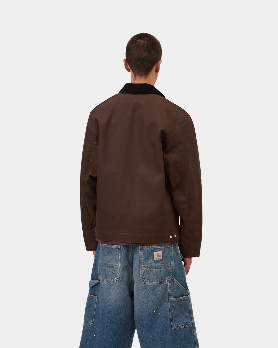 Back view of a Carhartt WIP Detroit Jacket in Tobacco / Black, showing the black collar and brown body, shown on model.