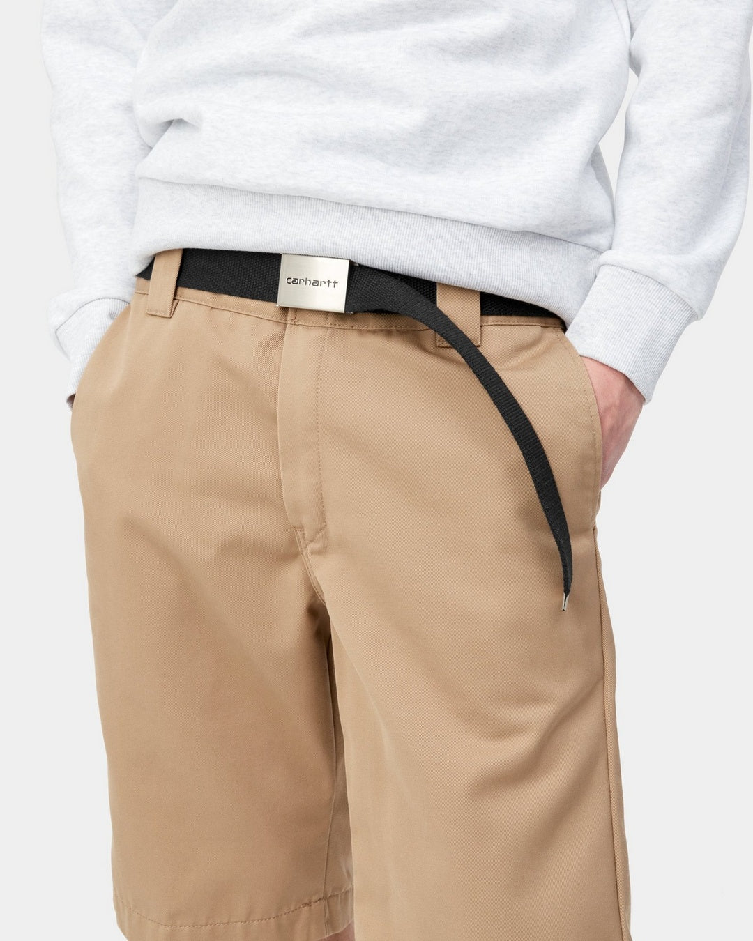 Carhartt WIP Clip Belt Chrome in black, worn with a chrome buckle and adjustable webbing strap.