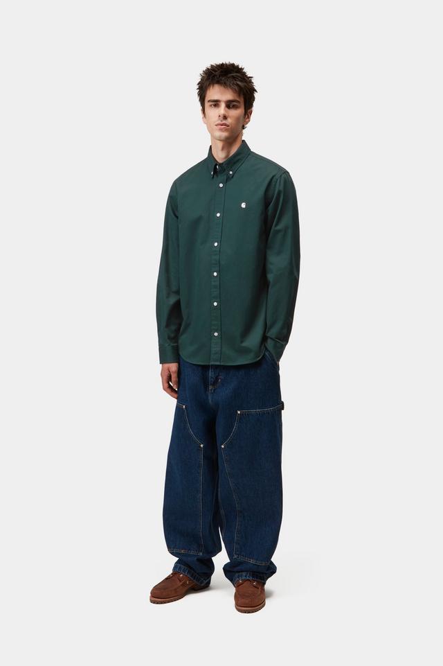 Person wearing a green shirt and blue jeans on a white background