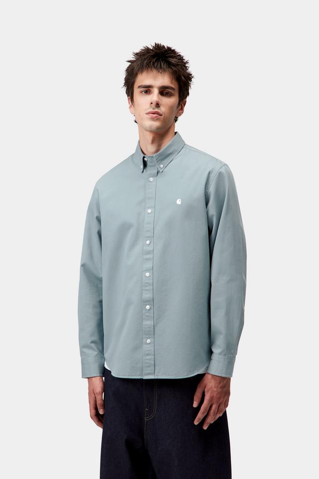 Man wearing a light blue button-up shirt on a white background