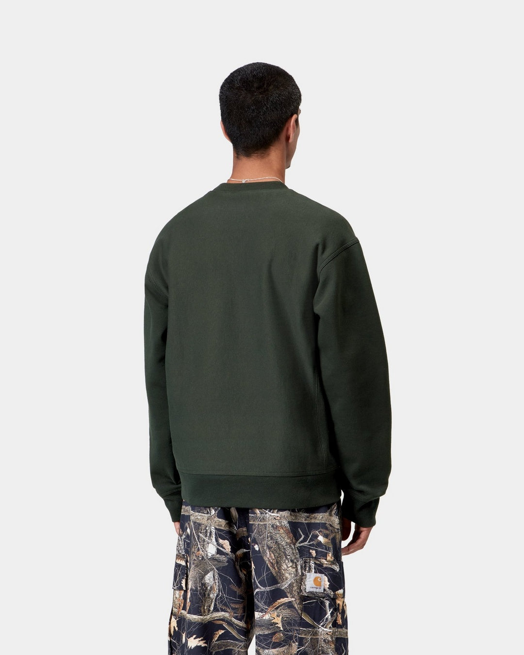 Carhartt WIP American Script Sweatshirt in Raven, back view, with ribbed cuffs and hem visible, shown on model.