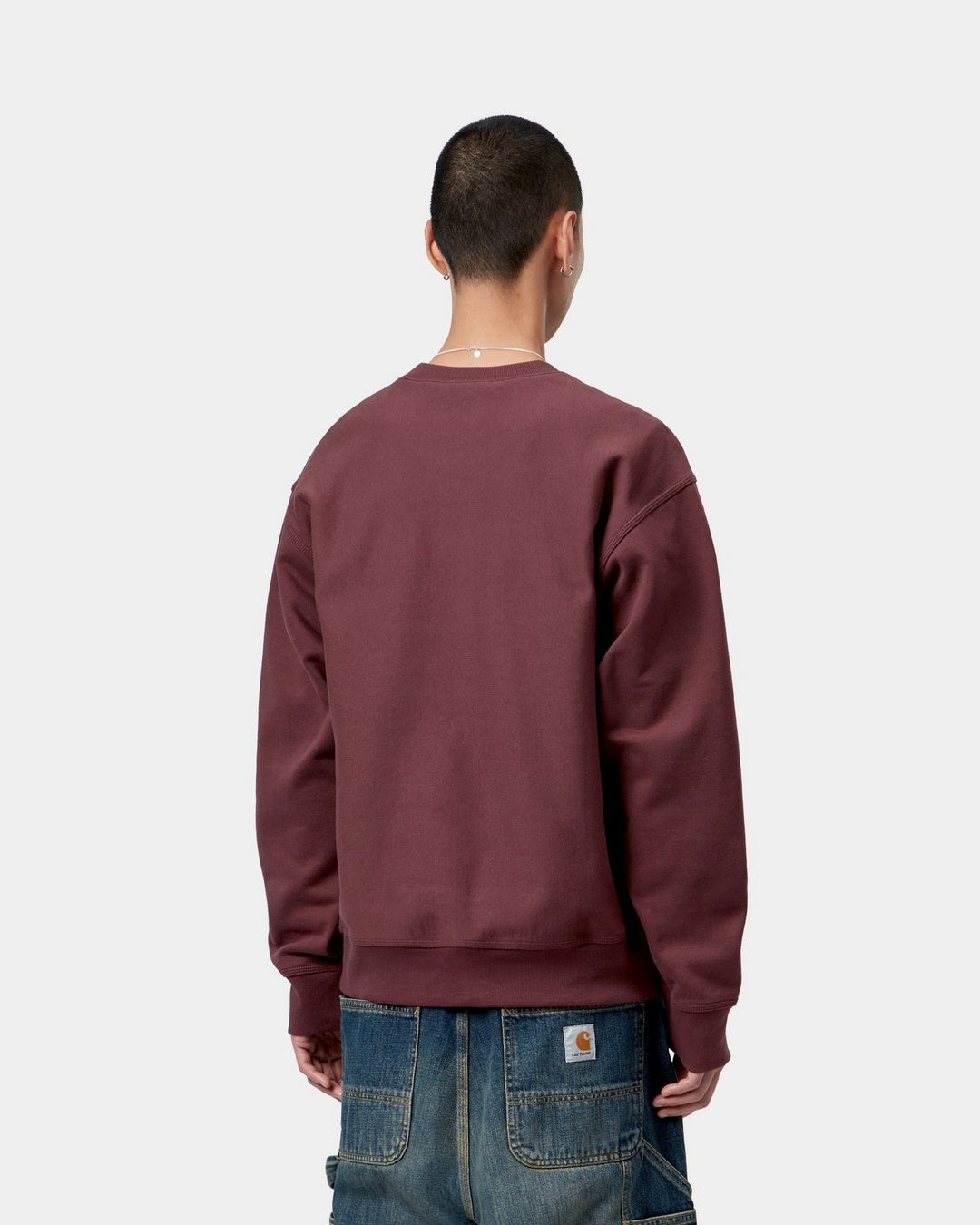 Carhartt WIP American Script Sweatshirt in Amarone, back view, worn over jeans.