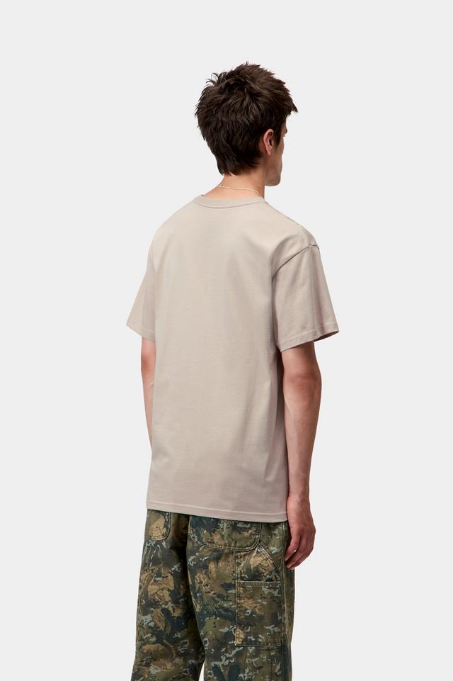 Man wearing a beige t-shirt with a small logo on a white background