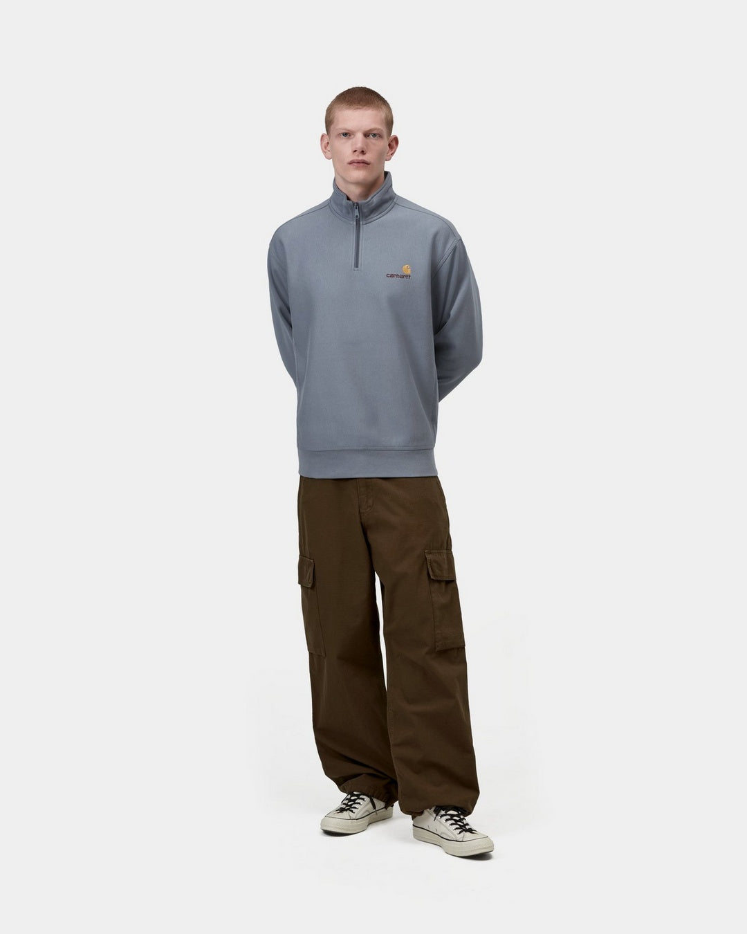 Carhartt WIP Half Zip American Script Sweatshirt in Shady Blue, front view on a model with half-zip high neck and small chest logo.