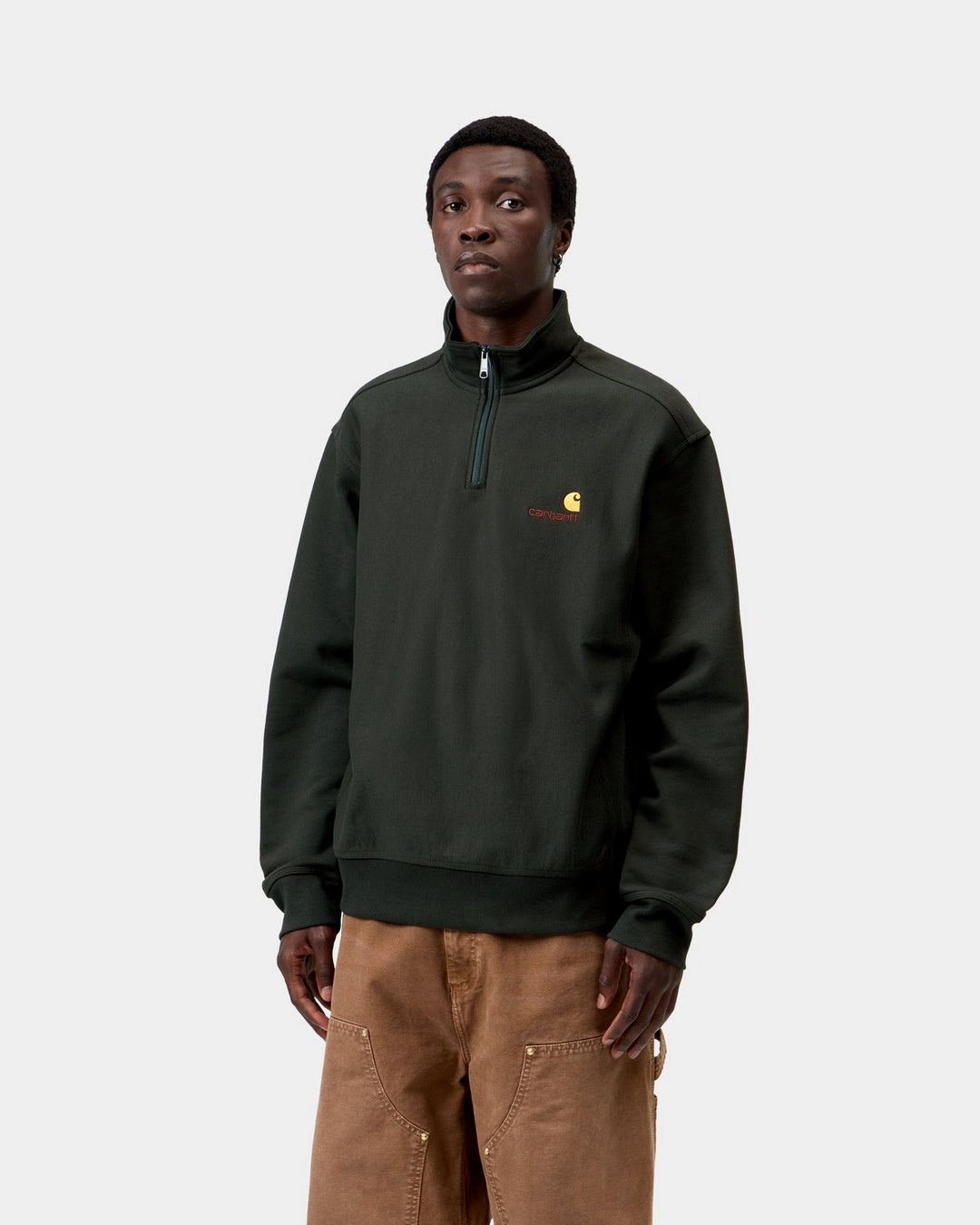 Carhartt WIP Half Zip American Script Sweatshirt in Raven, shown on a model with a half-zip high neck and small chest logo.