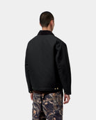 Carhartt WIP OG Detroit Jacket in Black / Black, back view, with corduroy collar and snap-adjustable hem, shown on model.