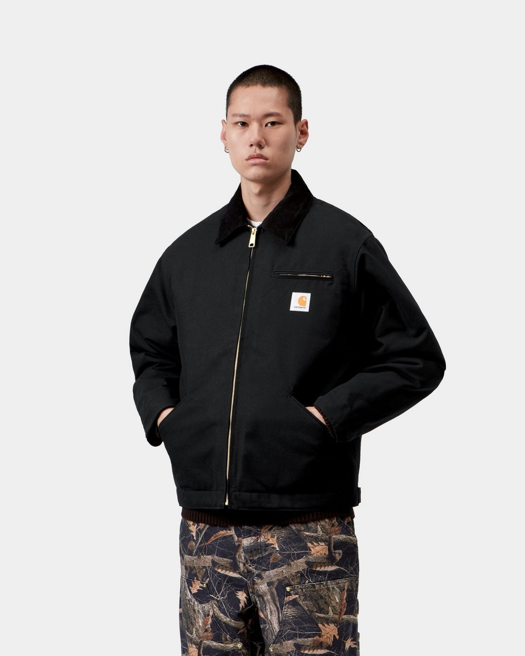 Carhartt WIP OG Detroit Jacket in Black / Black, front view, with zip front, corduroy collar, chest pocket and logo patch, shown on model.