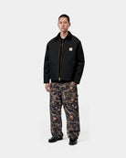 Carhartt WIP OG Detroit Jacket in Black / Black, front view on a model with corduroy collar, chest pocket, and zip front closure.