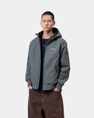 Carhartt WIP Hooded Sail Jacket in Styx / White, front view worn open. The jacket features a zip front, drawstring hood, two side zip pockets, rib-knit cuffs and hem, and a white Carhartt logo on the left chest.