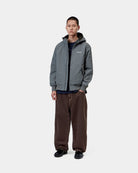 Front view of the Carhartt WIP Hooded Sail Jacket in Styx / White worn by a model, showing the zipped hood, chest logo, side pockets, and ribbed cuffs and hem.