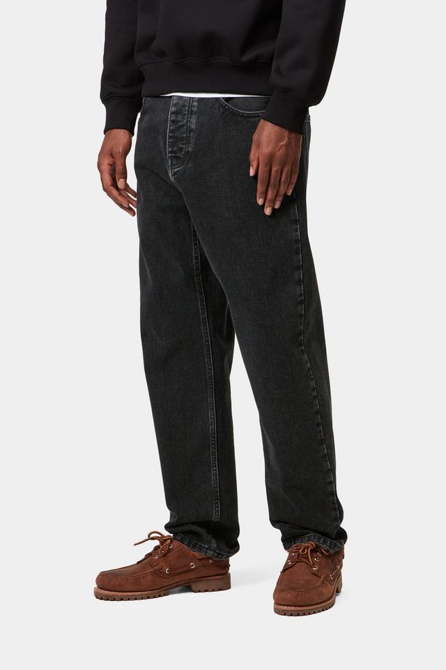 Man wearing black stone wash Newel jean pants and a black Carhartt sweatshirt-from the side