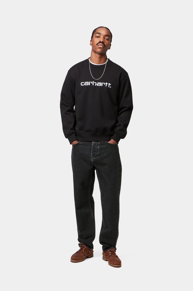Man wearing black stone wash Newel jean pants and a black Carhartt sweatshirt