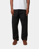 Carhartt WIP Newel Pant in black, shown on model from the front.