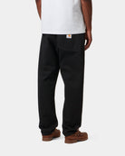 Carhartt WIP Newel Pant in Black, back view, with rear pockets and woven Square Label visible.