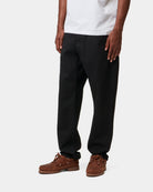 Carhartt WIP Newel Pant in Black, shown on model with a relaxed tapered fit.