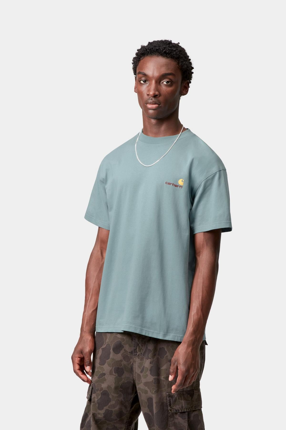 Person wearing a light blue t-shirt and camouflage pants on a white background