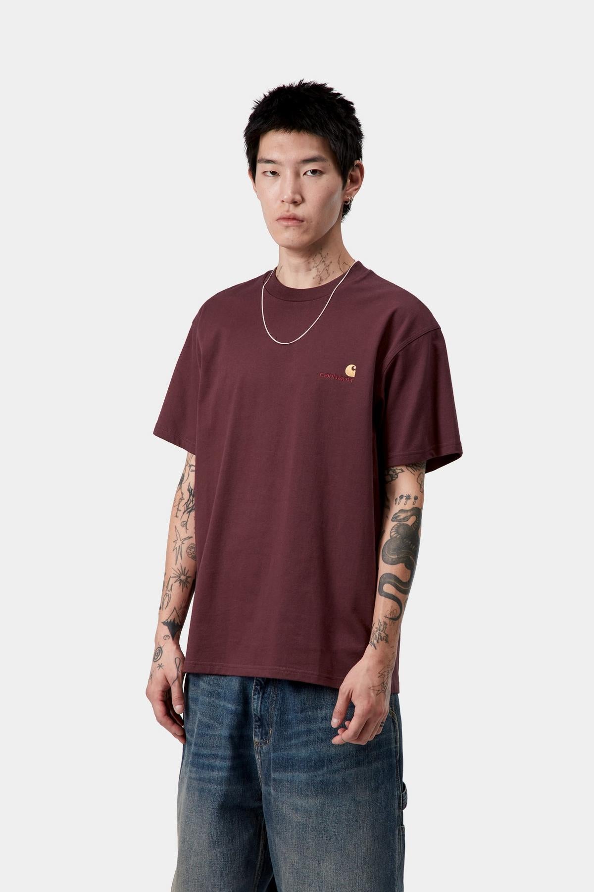Person wearing a maroon t-shirt and blue jeans on a white background