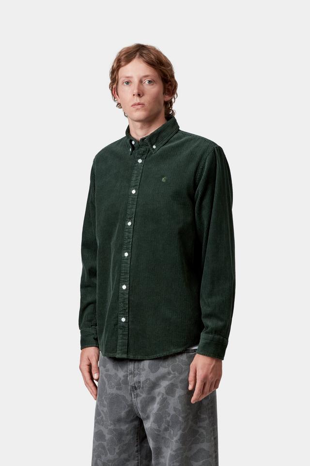 Person wearing a green button-up shirt and gray pants on a white background