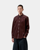 Carhartt WIP L/S Madison Cord Shirt in Amarone, shown on model with front view, button-down collar, long sleeves, and chest logo embroidery.