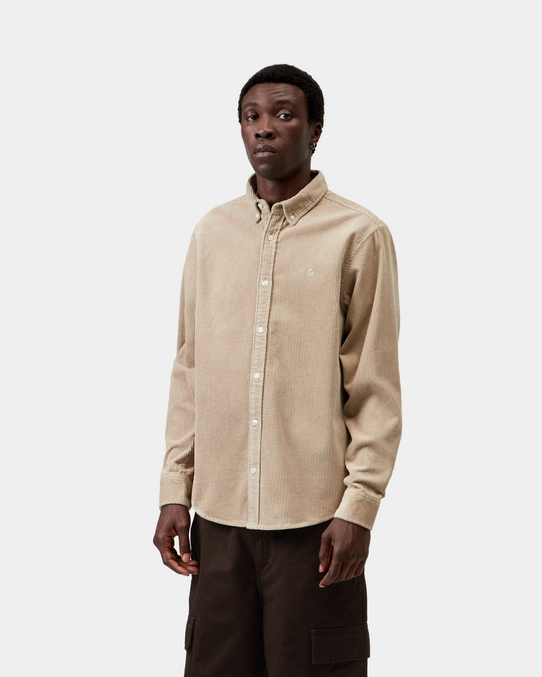 Carhartt WIP L/S Madison Cord Shirt in Wall, shown front view on a model with button-down collar and chest logo embroidery.