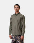 Carhartt WIP L/S Bolton Shirt in Shungite, shown front view with button-down collar and long sleeves, shown on model.