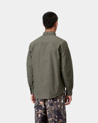Carhartt WIP L/S Bolton Shirt in Shungite, back view, worn by model with curved hem and button-down collar visible.