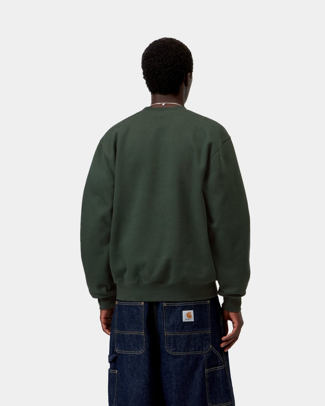 Carhartt WIP sweatshirt shown from the back in Dark Scarab, with ribbed hem and cuffs, shown on model.