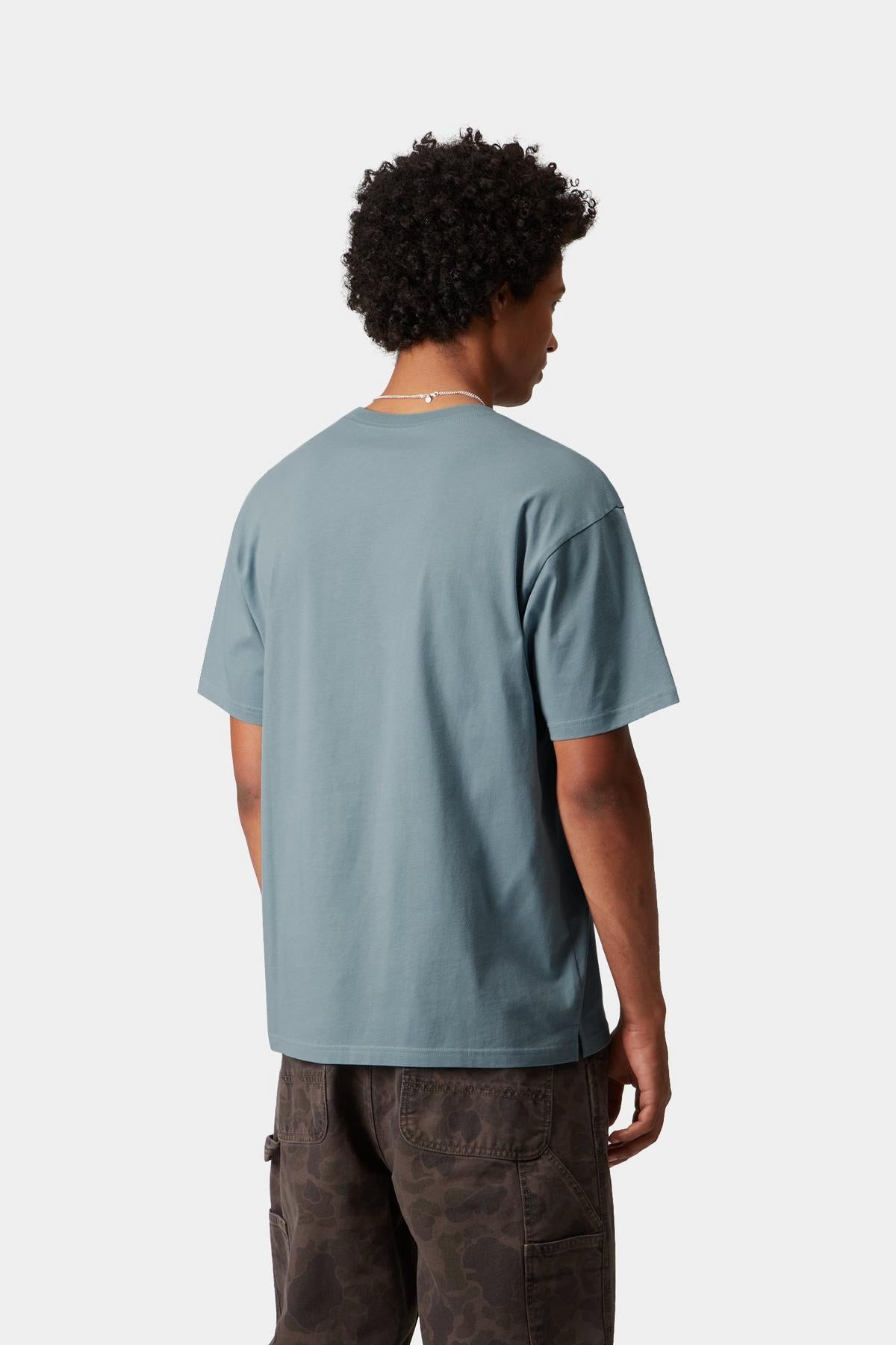Person wearing a light blue t-shirt and dark pants on a white background