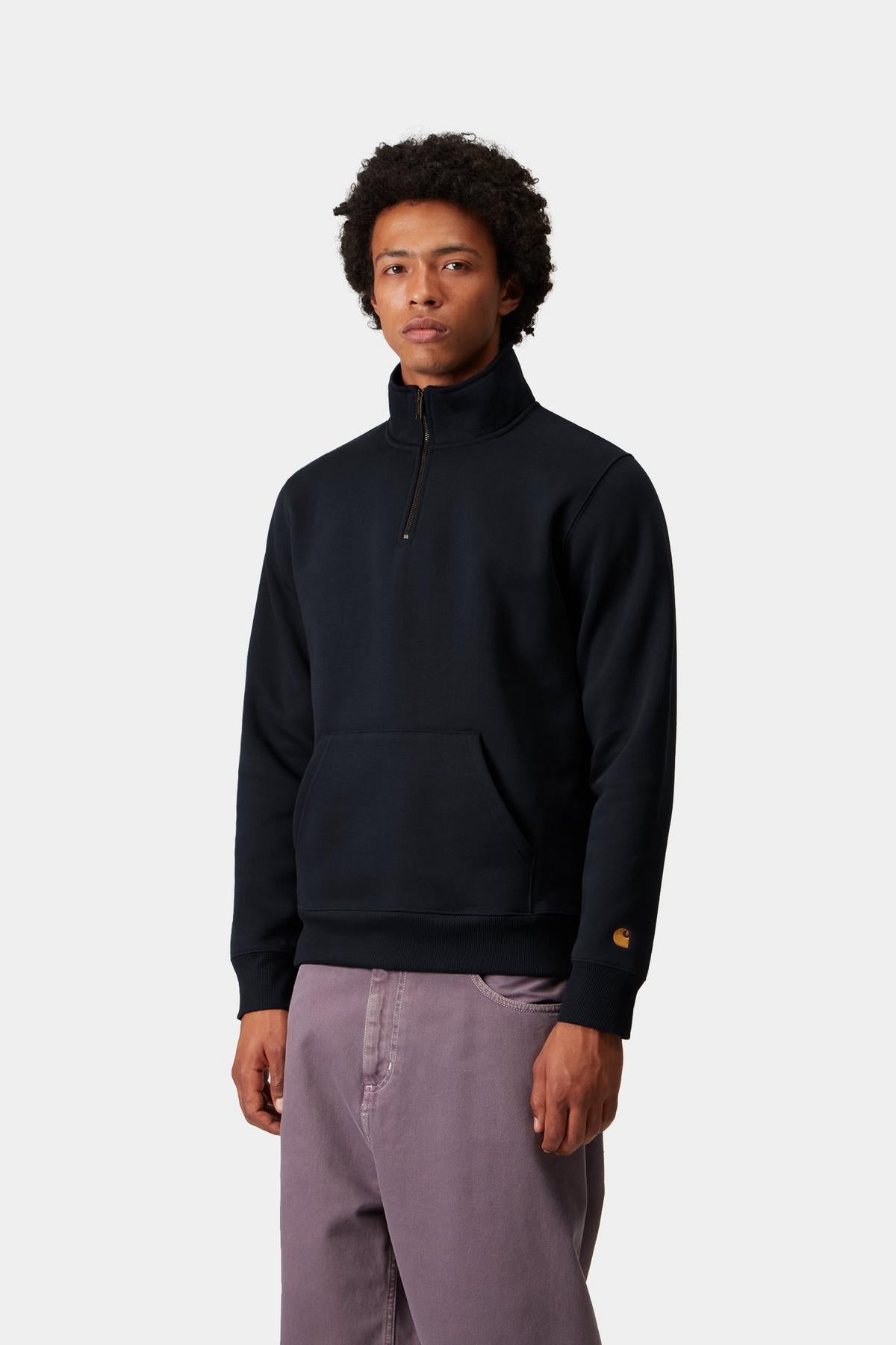 Person wearing a navy zip sweat and light purple pants on a white background