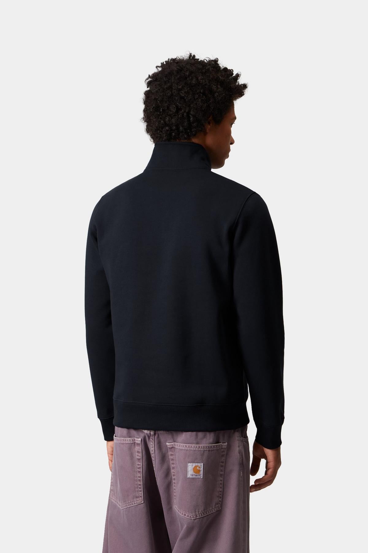 Person wearing a navy zip sweat with a visible brand logo on a white background