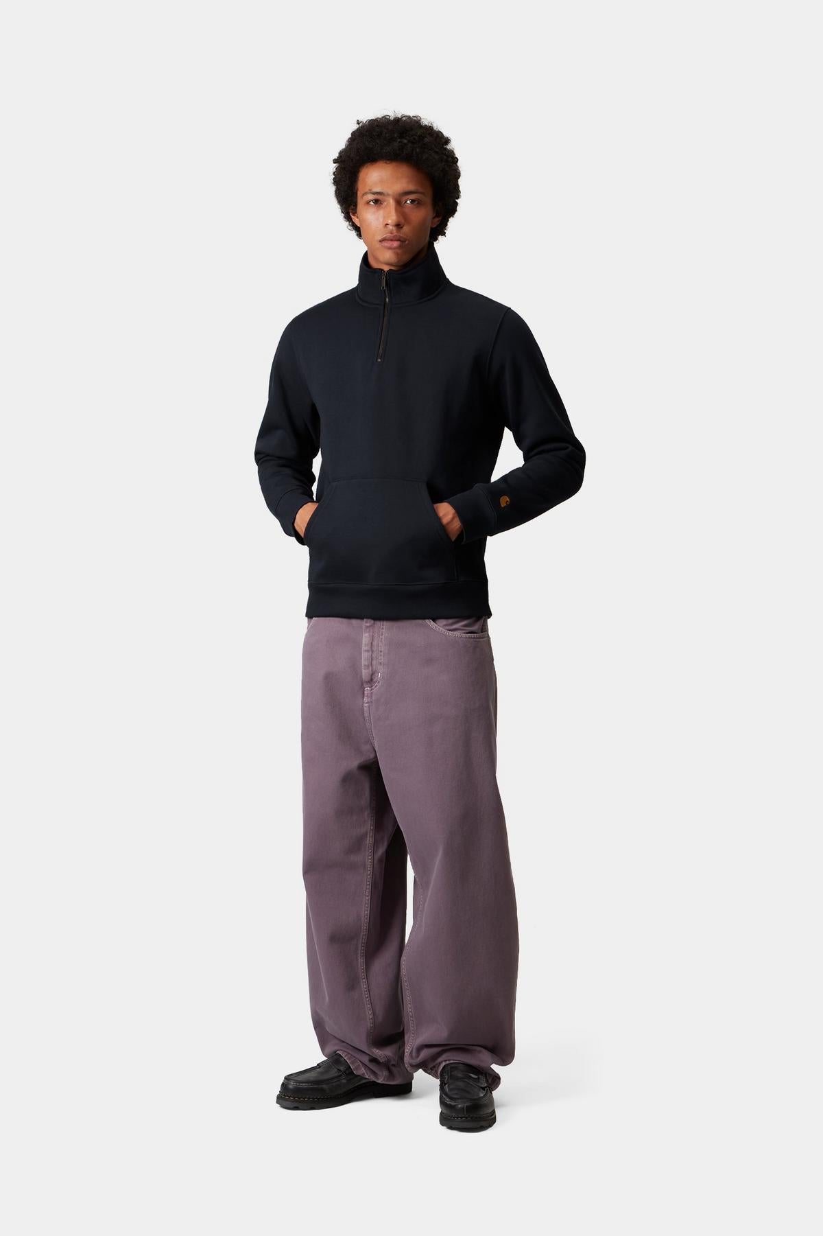 Person wearing a navy zip sweat and purple pants on a white background