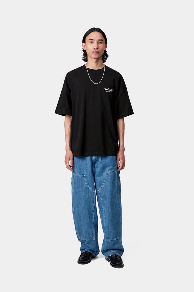 Person wearing a black oversized t-shirt and blue jeans on a white background