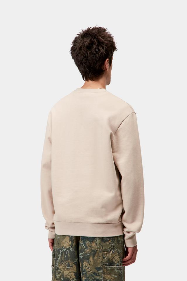 Person wearing a beige sweatshirt and camouflage pants on a white background