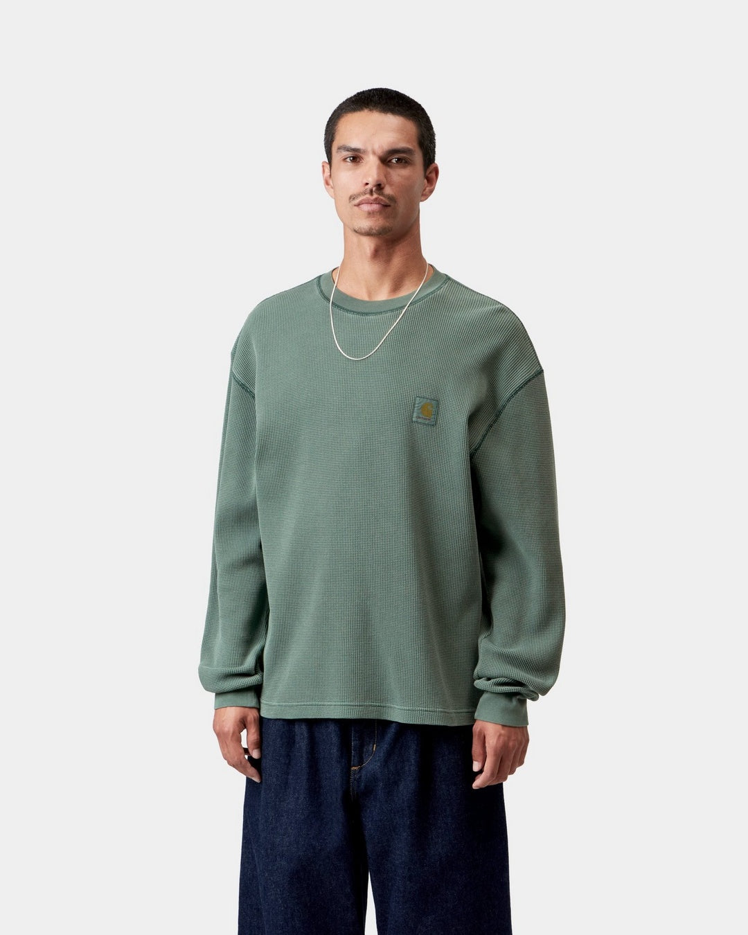 Carhartt WIP L/S Vista Waffle T-Shirt in Dark Scarab, front view, worn by model with woven chest Square Label and long sleeves.