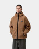 Carhartt WIP Blevin Liner in WIP H Brown, front view, with adjustable hood, zip front, and logo patch on chest, shown on model.