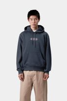 Person wearing a dark blue hoodie with a logo on a white background
